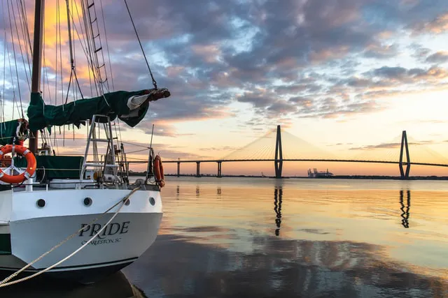 A picture of a boat in Charleston Harbor during a sunset
