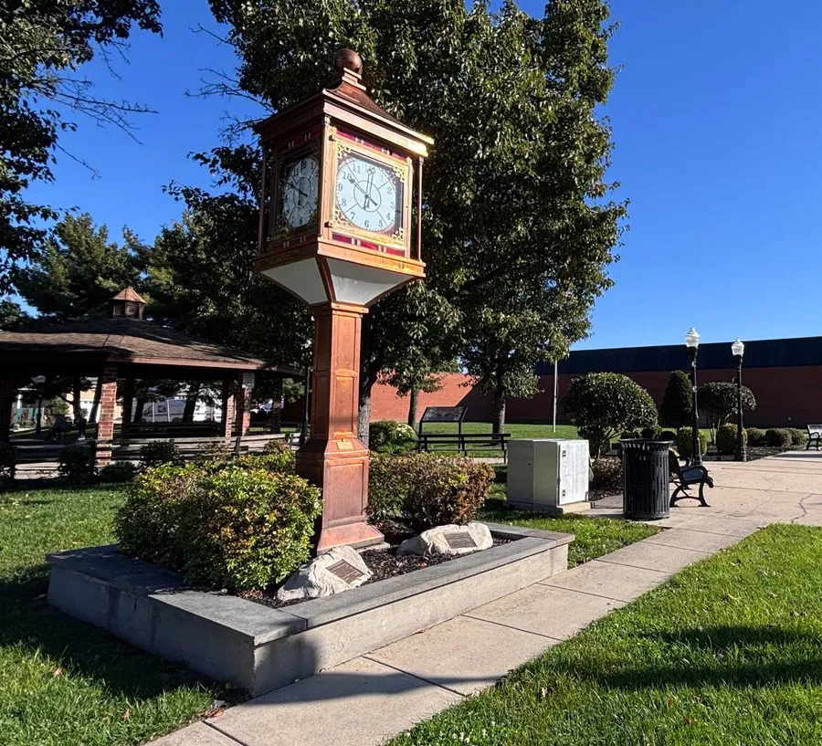 Copper town clock with the gazebo, park and a red brick building behind it in Maple Shade, NJ