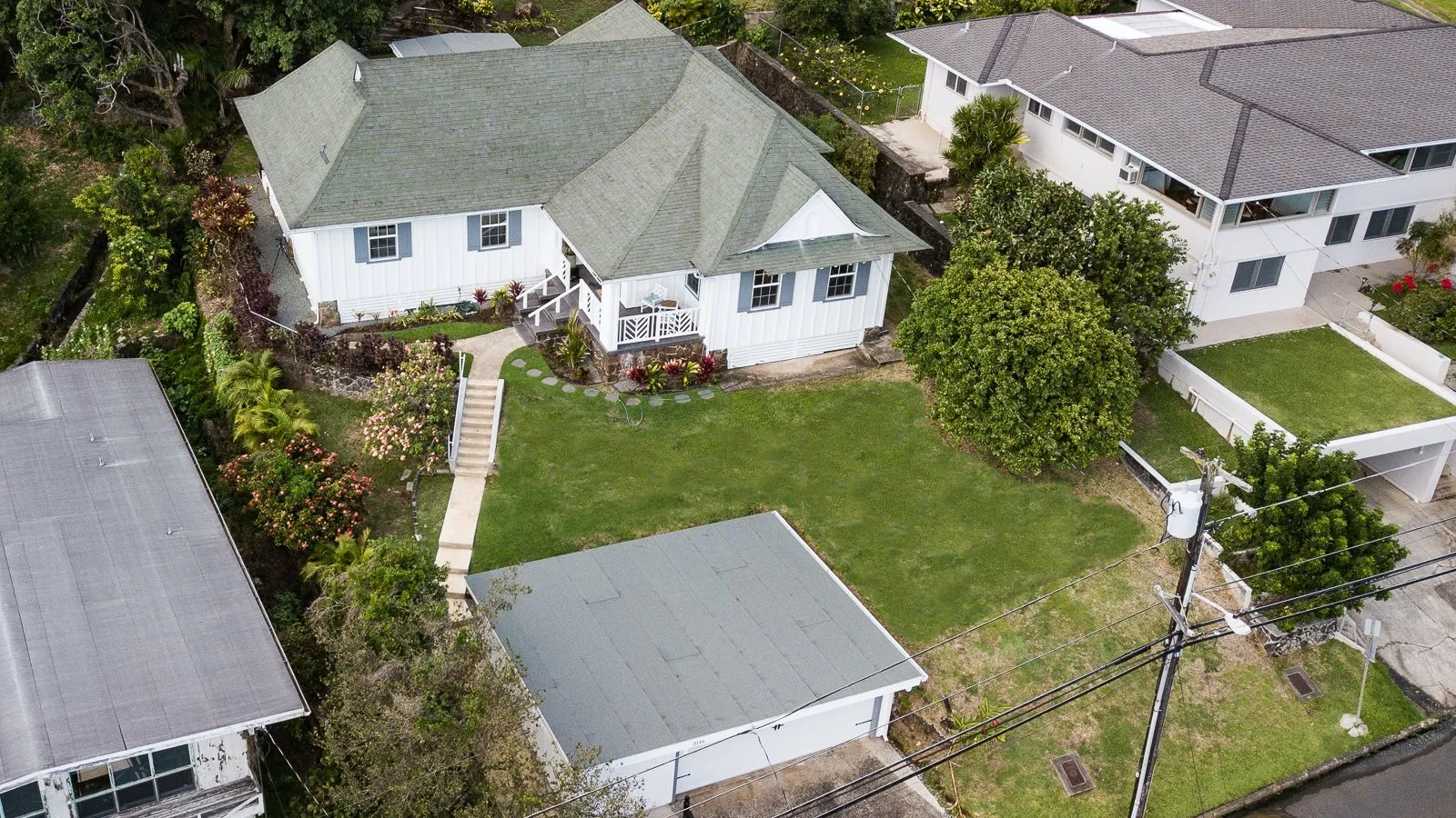 Aerial view of a Honolulu home with a green roof among neighboring houses