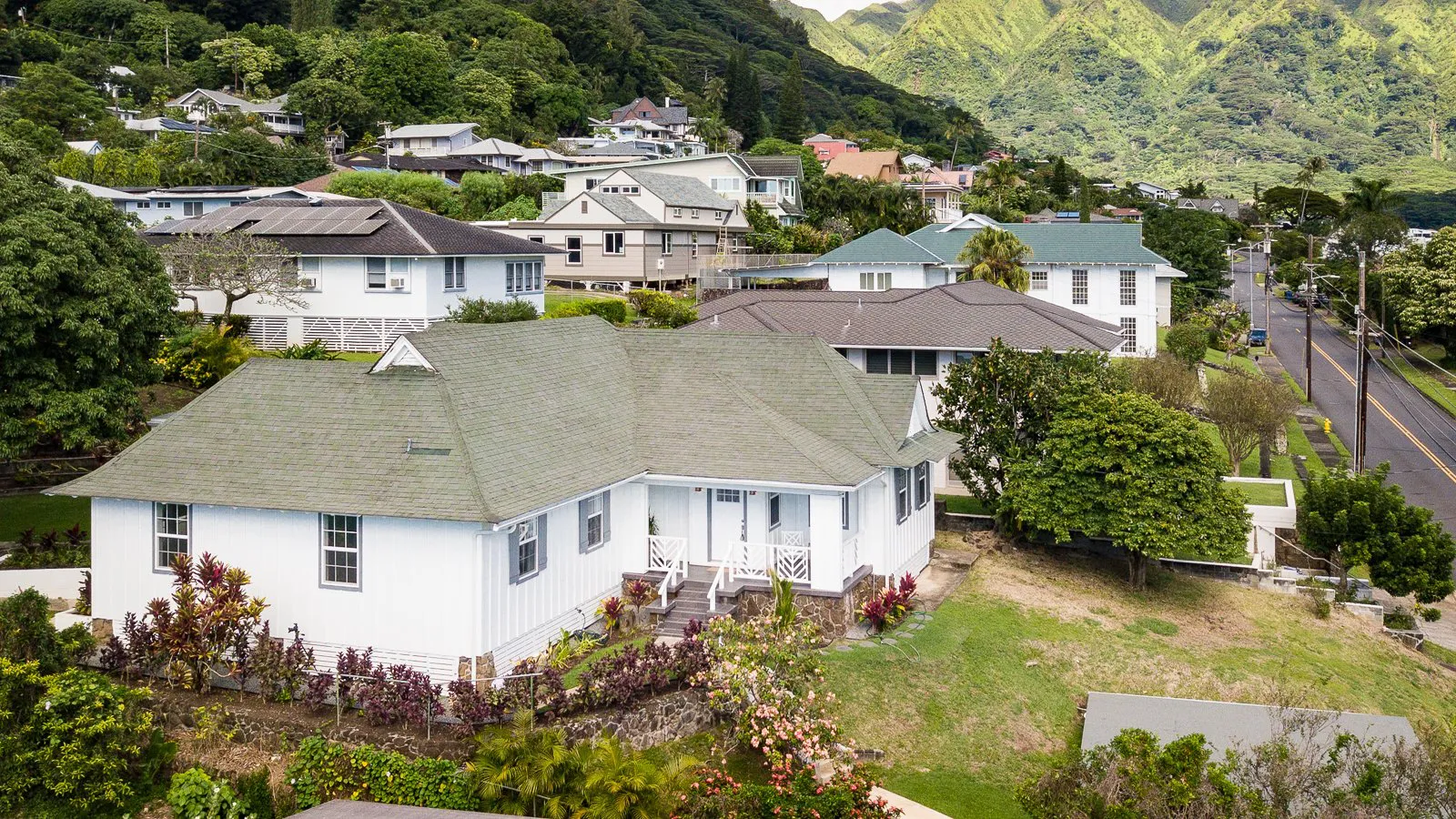 Aerial view of Manoa Valley homes and streets with the green Koolau ridges behind
