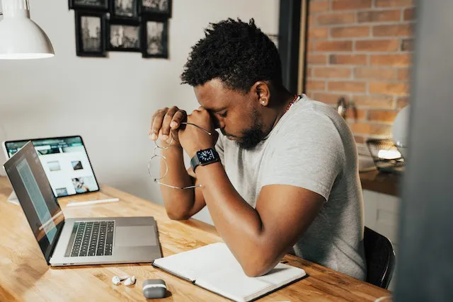 Man sitting at a desk in front of a laptop.