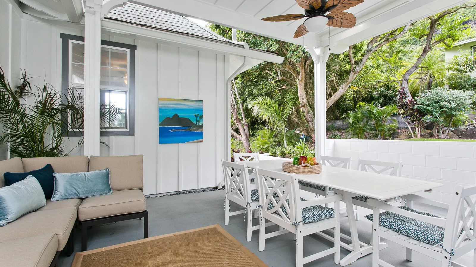 Covered lanai with seating and ceiling fan at a renovated Manoa home