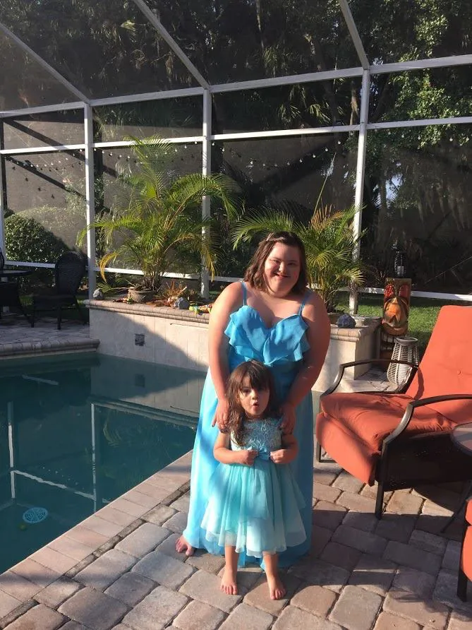 A family moment by the pool in matching blue dresses