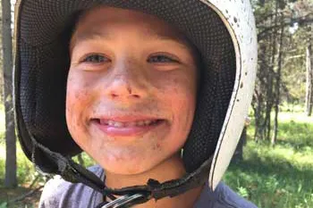 Young boy wearing helmet while riding a quad bike in Island Park