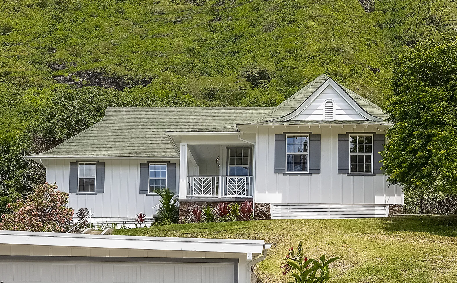 Front of an older Manoa home with a lawn and mature trees